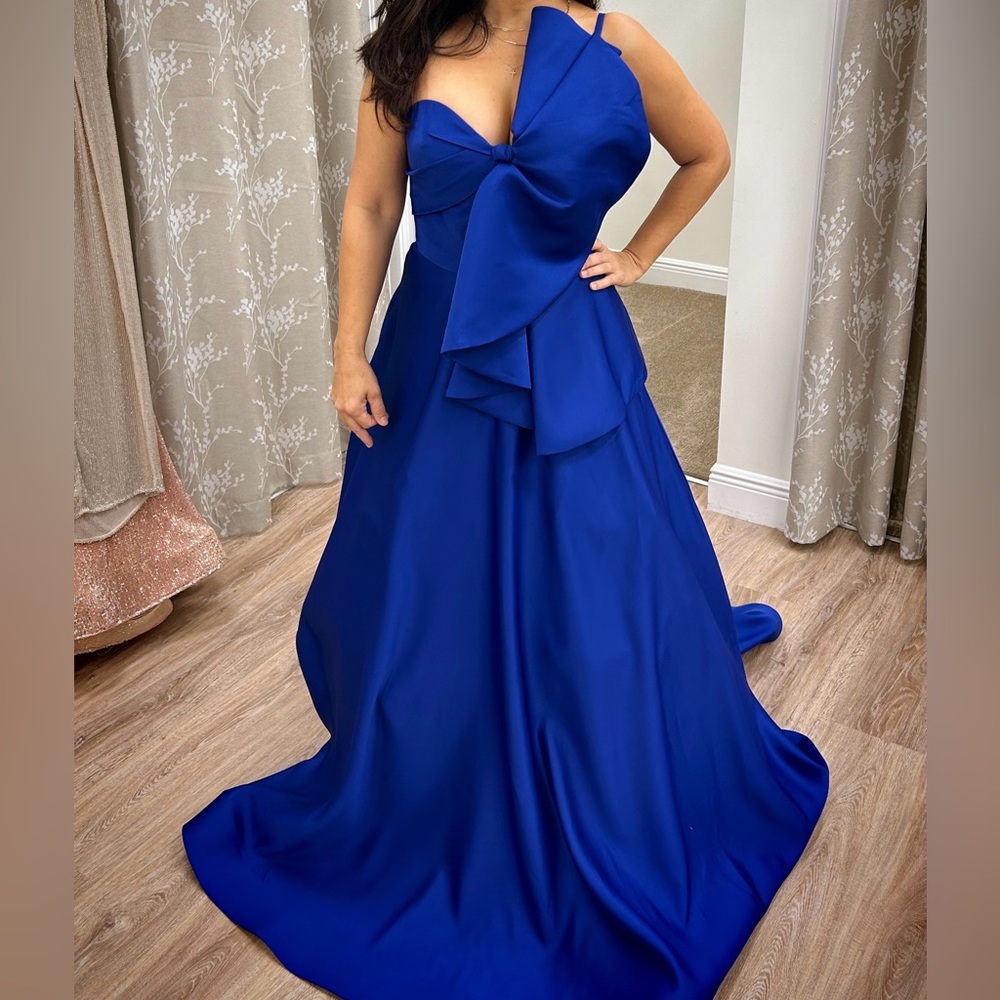 Terani Couture, this gown features: Stretch matte satin fabric One shoulder Bow